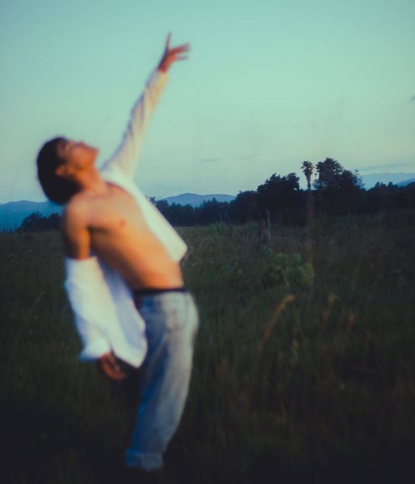 Man in a calm, balanced pose outdoors with a natural background.